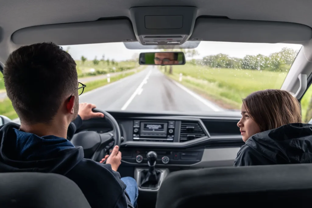 Chauffeur en kind in auto op tweebaansweg