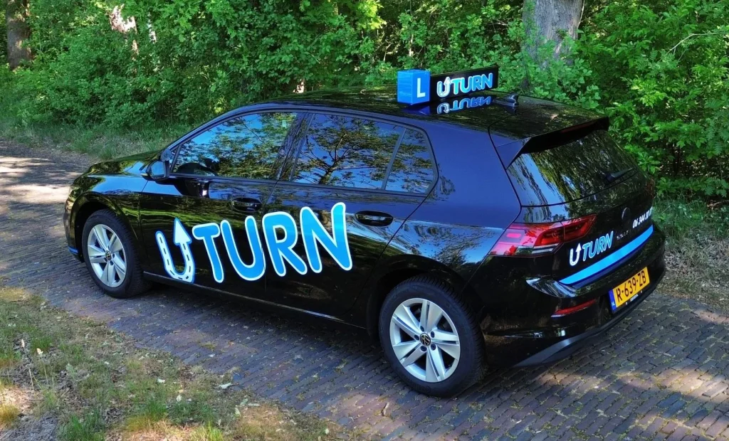 Zwarte rijschoolauto met Uturn branding op de zijkant